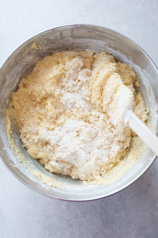 flour mixture is being mixed into the cake batter