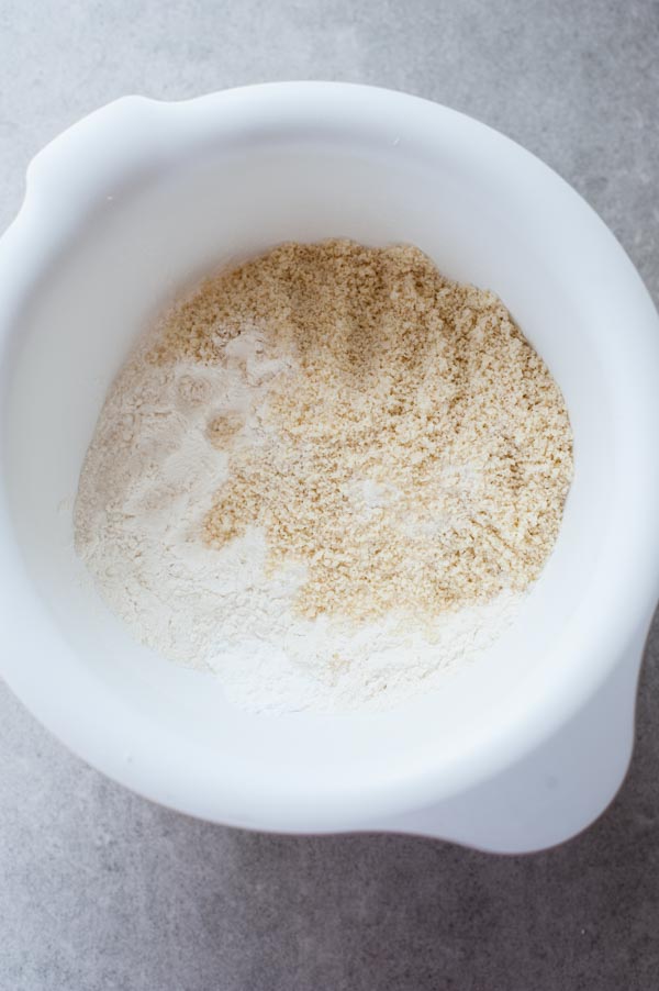 flour, ground almonds and baking powder in a white bowl