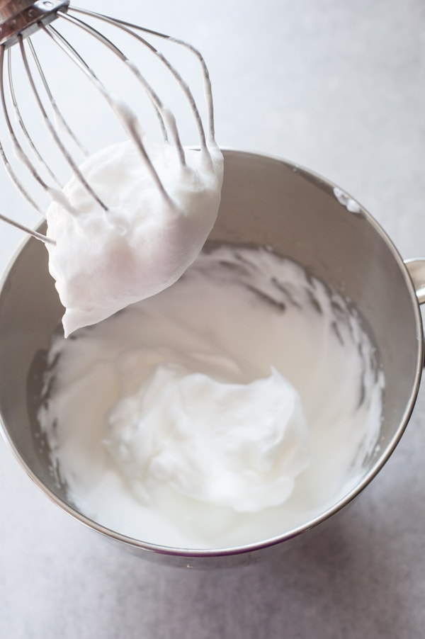 whipped egg whites in a metal bowl