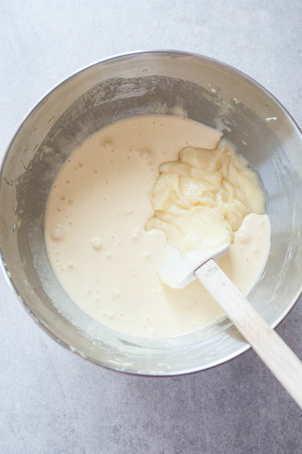 beaten egg yolks with sugar and molten white chocolate in a metal bowl