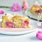 a slice of coconut cake with strawberries on a rose plate