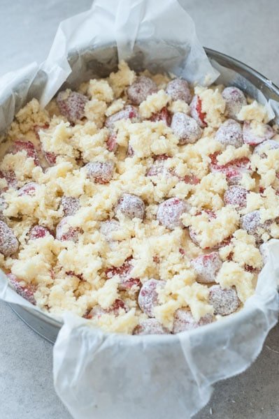 coconut cake with strawberries and coconut crumble before baking