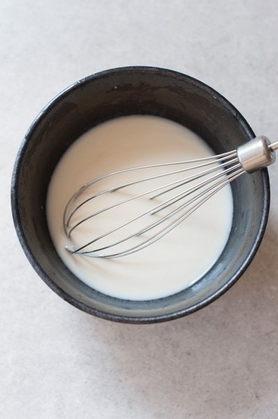 coconut liqueur, vanilla extract and yogurt in a black bowl