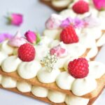 close up picture of number cake with lemon cream and raspberries