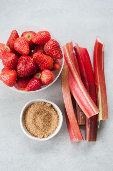 składniki na nadzienie tarty: truskawki, rabarbar i cukier