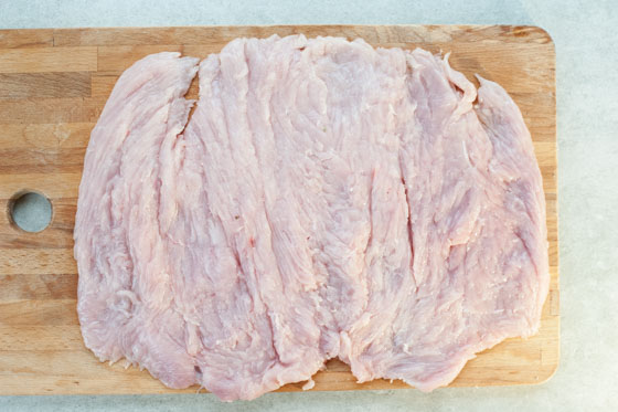 butterflied and pounded turkey breast on a chopping board