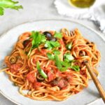 spaghetti alla puttanesca on a blue plate