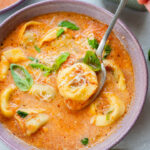 tomato tortellini soup in a violet bowl