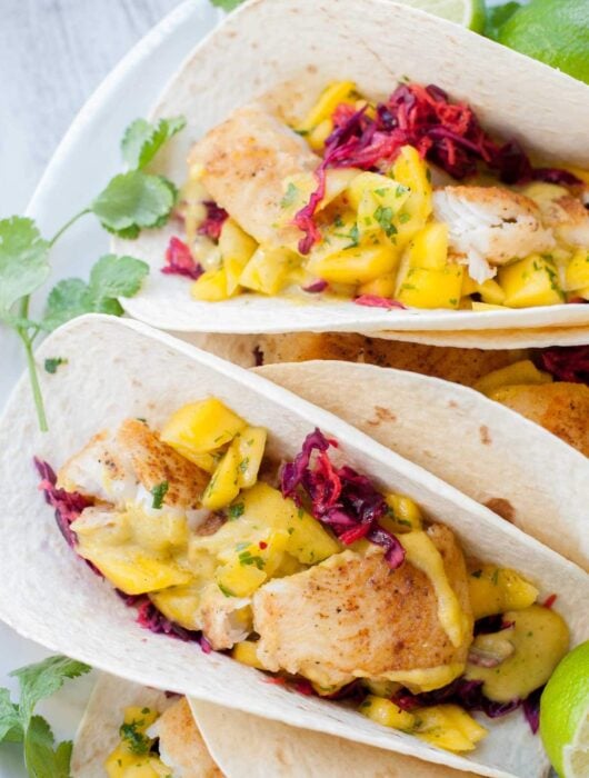 Fish tacos with mango salsa on a plate.