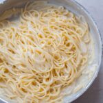 Spaghetti cacio e pepe in a metal pan.