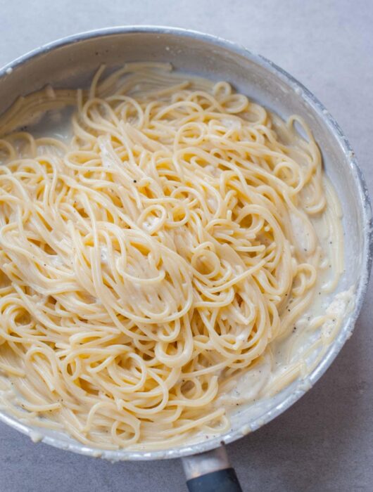 Spaghetti cacio e pepe in a metal pan.