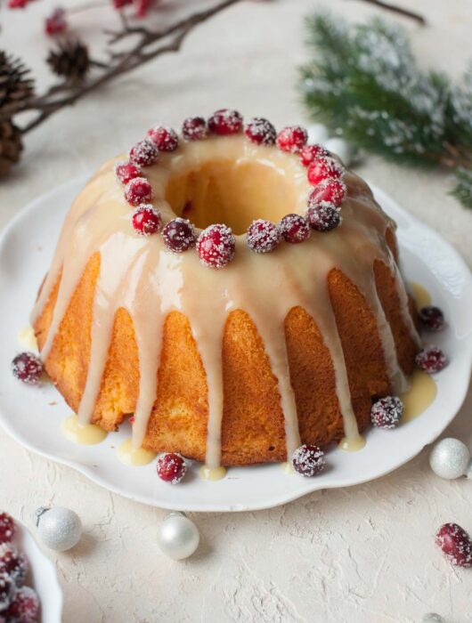 Cranberry orange bundt cake with white chocolate orange glaze and sugared cranberries.
