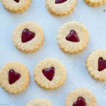 Raspberry Linzer cookies on a blue background.