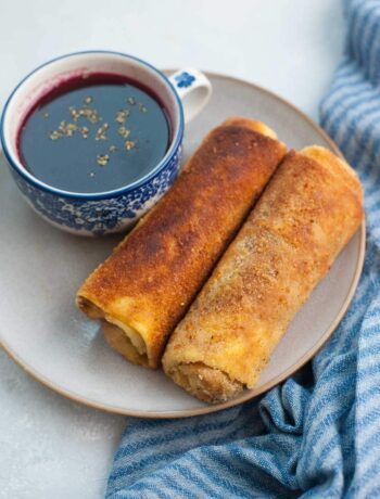 Polish croquettes on a brown plate with a cup of borscht.