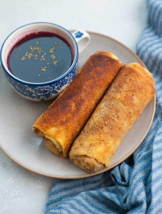 Polish croquettes on a brown plate with a cup of borscht.