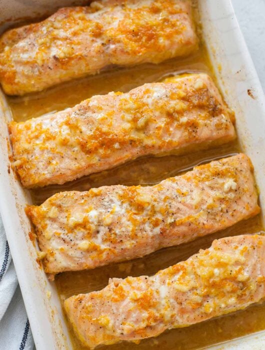 Orange maple salmon in a white baking dish.