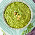 Arugula pistachio pesto in a green bowl.