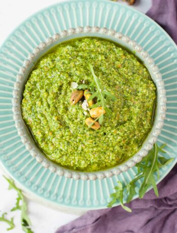 Arugula pistachio pesto in a green bowl.