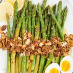 Asparagus almondine topped with almonds garlic. Hard-boiled eggs and lemon slices on the side.