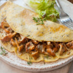 Chanterelle mushroom omelette on a white plate.