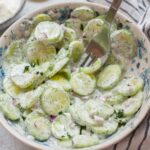 Mizeria (Polish cucumber salad) in a white bowl.