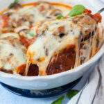 Mozzarella chicken in a white baking dish.