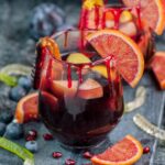 Two glasses with Halloween sangria garnished with blood orange slices.