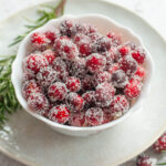 Sugared cranberries in a white bowl.