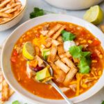 Turkey tortilla soup in a white bowl.