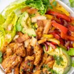 Chicken fajita salad on a white plate.