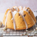 Polish Easter babka glazed with icing on a black cooling rack.