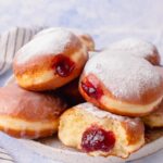 Polish doughnuts paczki on a white plate.