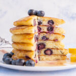 A stack of blueberry buttermilk pancakes with a part missing.