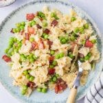 Bacon and peas pasta on a blue plate.