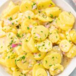 Austrian potato salad in a beige bowl.