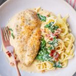 Tuscan chicken pasta on a beige plate.