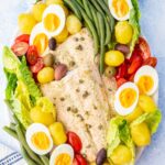 Salmon Nicoise salad on a white plate.