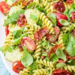 Pesto pasta salad on a white plate.