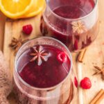 Two glasses with mulled wine on a wooden board.