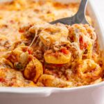 Tortellini bake in a white casserole dish.