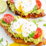 Avocado egg toast on a white board.