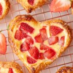 Valentine's strawberry puff pastry hearts on a cooling rack.