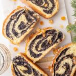 Slices of poppy seed roll on a marble board.